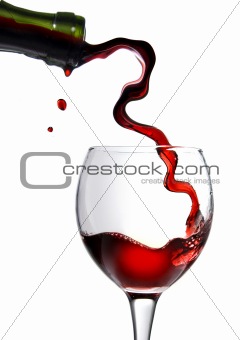 Pouring red wine in goblet isolated on white