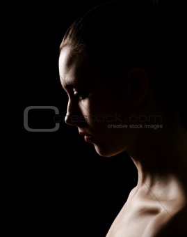 Low key portrait of a young woman with side lighting