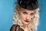 gorgeous retro girl in forties hat with feathers