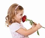 Happy little girl smelling a rose
