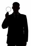silhouette of man with magnifying glass