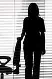 silhouette of woman standing next to the chair (blind)
