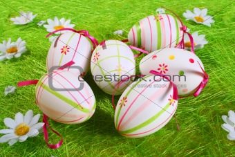 Closeup of several Easter eggs over green artifial grass.