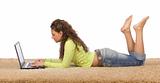 female teenager lying on the carpet with laptop