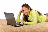 female teenager lying on the carpet with laptop