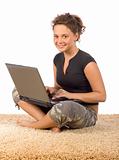 female teenager sitting on the carpet with laptop
