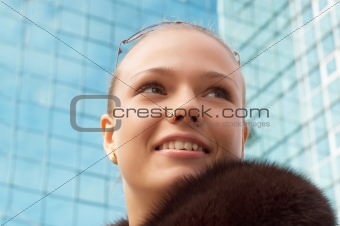 soft portrait of girl with fur, on the mirror building background