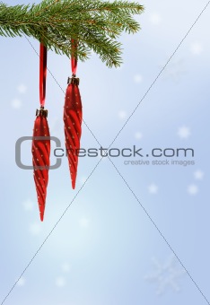 red christmas ornament on branch on blue background