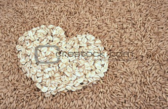 Oats seeds and oat-flakes heart - background