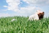 happy woman in green grass over sky background