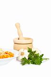 Plate of pasta, parsley, garlics and wooden mortar