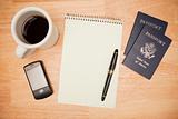 Overhead Pad, Pen, Passports, Coffee and Cell Phone on a Wood Background.