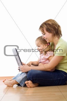 Woman and little girl watching laptop