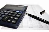 Calculator and pen on balance sheet