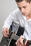 Young Man Strums Acoustic Guitar