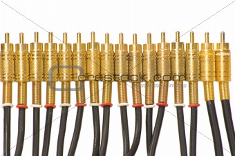 A closeup of a line of gold plated RCA jacks pointing upwards on a white background.