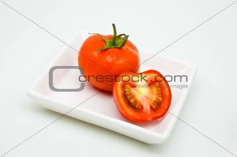 Tomoato on plate, white background.