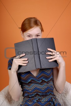 The woman hides the face behind the book