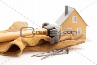 Hammer, Gloves, Nails and House Isolated on a White Background.