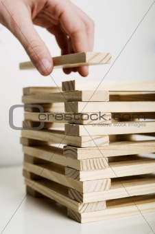 Hand puts block on tower