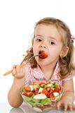 Little girl eating fruit salad