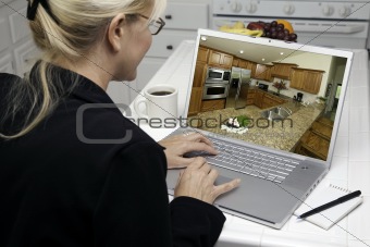 Woman In Kitchen Using Laptop to Research Home Improvement Ideas.