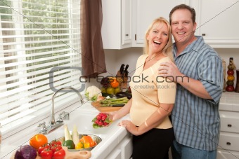 Happy Couple Enjoying An Eveing Preparing Food in the Kitchen.