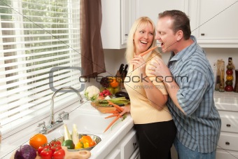 Happy Couple Enjoying An Eveing Preparing Food in the Kitchen.