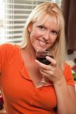 Attractive Blond with a Glass of Wine in the Kitchen