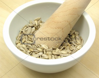 Pestling sunflower seeds in a bowl of chinaware