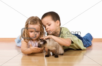 Kids with their kitten on the floor