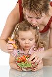 Woman and little girl preparing fruit salad