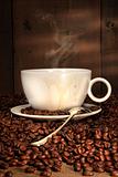 White coffee cup with spoon on roasted beans 