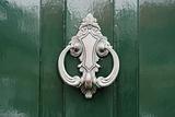 Doorknocker in silver on green painted wooden door