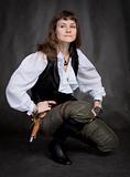 Girl - pirate with pistol sit on black