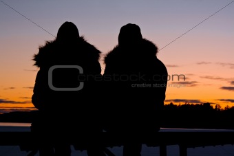 silhouettes of a couple watching the sunset