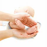 baby's feet in parent's hands over white