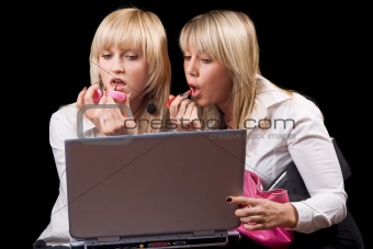Two blondes do makeup in front of the laptop screen