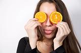 Portrait of beautiful young woman holding orange fruit