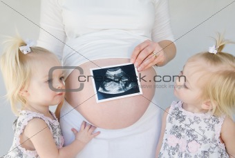 Twins Looking at New Baby
