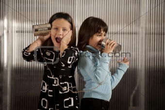 Little girl getting shocking message on tin can phone