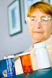 Elderly woman looking at pill bottles