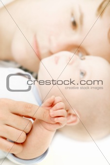 baby holding mother's finger over white
