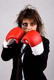 businesswoman wearing boxing gloves with bruised eye