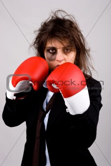 businesswoman wearing boxing gloves with bruised eye