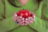 young woman holding healthy red apple in the hands