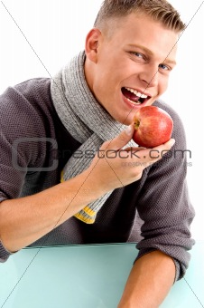 smiling young man posing with apple
