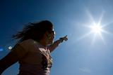 young woman pointing at the sun