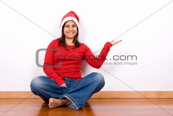 young woman with red christmas hat sitting in house floor