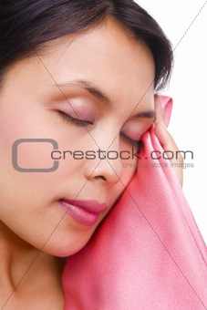 Young woman touching smooth satin with her face (close up)